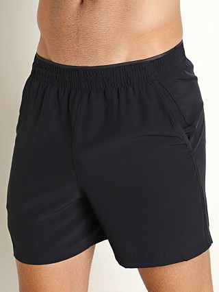 Model in black Under Armour Qualifier 5" Performance Shorts