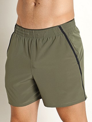 Model in marine green Under Armour Qualifier 5" Performance Shorts