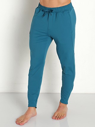 Model in tourmaline teal Under Armour Meridian Tapered Pants