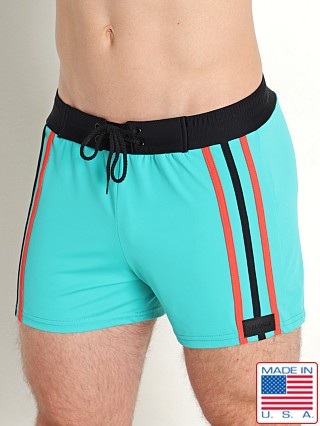 Model in jade/black/coral Sauvage Italian Side Striped Swim Trunk