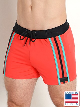 Model in coral/black/jade Sauvage Italian Side Striped Swim Trunk